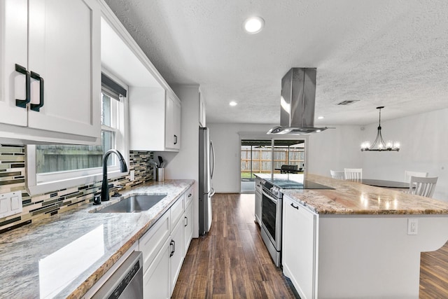 kitchen with stainless steel appliances, island exhaust hood, white cabinets, and a sink