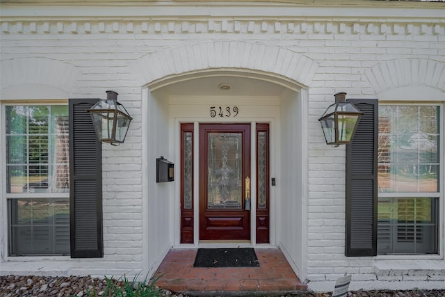 doorway to property featuring brick siding