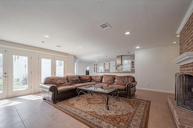 living room with light tile patterned flooring, a fireplace, and visible vents