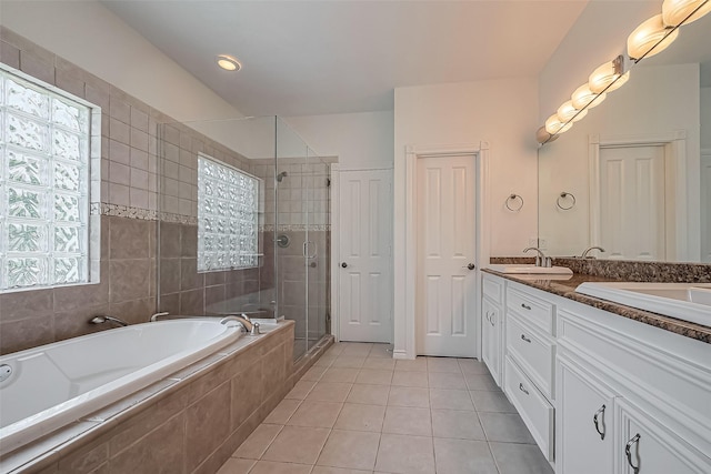 bathroom with double vanity, a stall shower, a garden tub, tile patterned flooring, and a sink