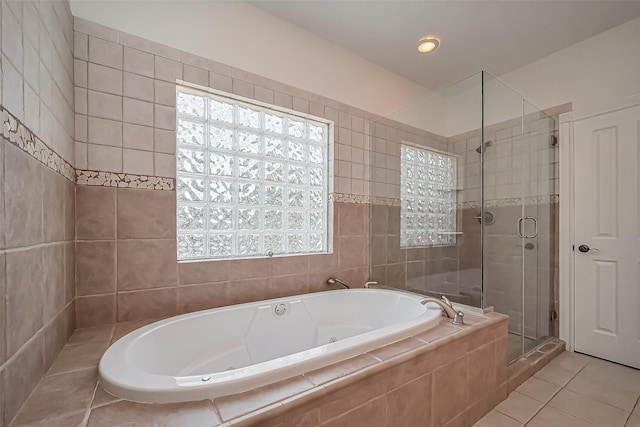 full bath featuring a tub with jets, a stall shower, and tile patterned flooring