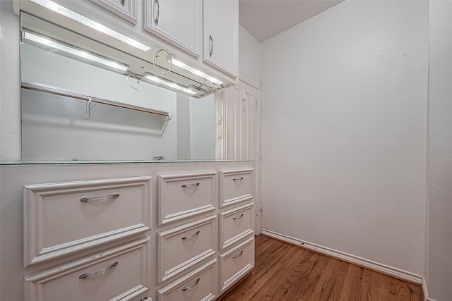 bathroom with wood finished floors and baseboards