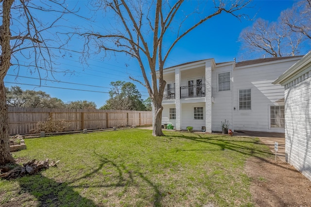 view of yard with fence and a balcony