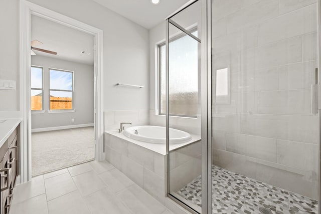 full bathroom featuring ceiling fan, a garden tub, baseboards, a shower stall, and tile patterned floors