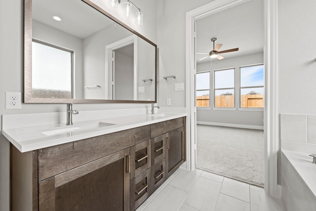 bathroom featuring double vanity, a sink, a ceiling fan, and tile patterned floors