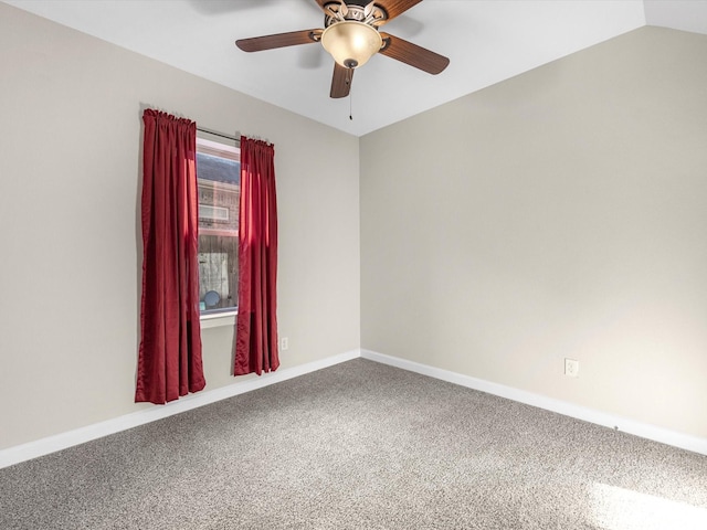 carpeted empty room featuring vaulted ceiling, baseboards, and ceiling fan