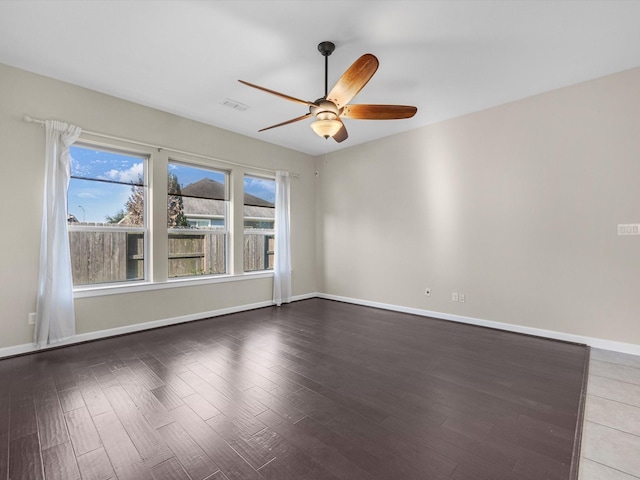 empty room with visible vents, ceiling fan, baseboards, and wood finished floors