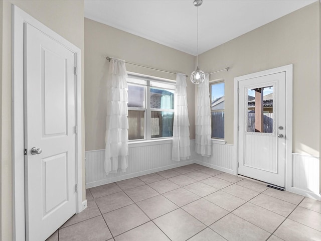 unfurnished dining area with wainscoting and light tile patterned flooring