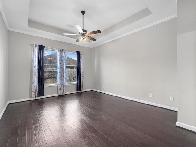 unfurnished room with dark wood-style flooring, a raised ceiling, a ceiling fan, and baseboards