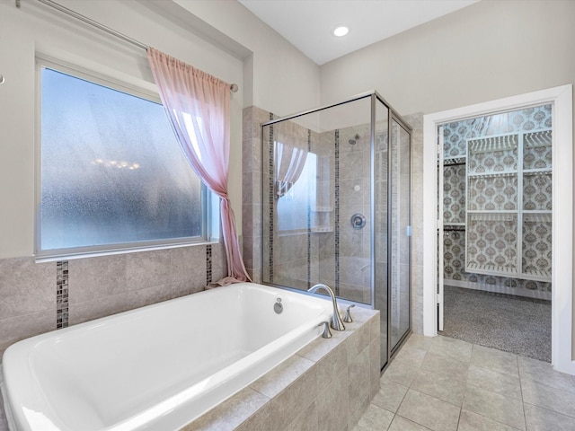 bathroom featuring a stall shower, a garden tub, and tile patterned floors