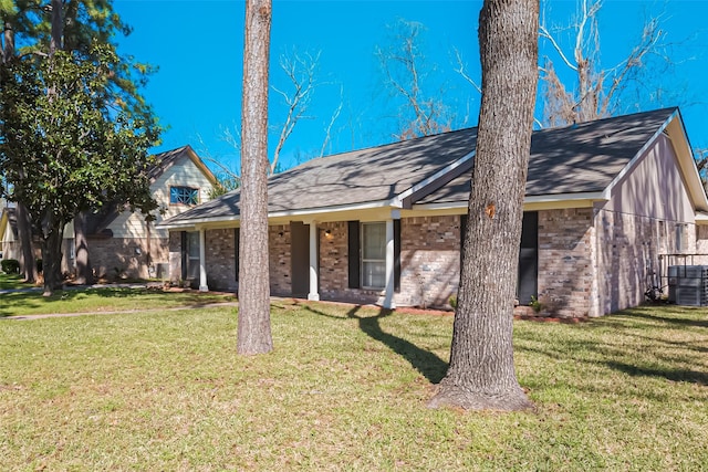 view of front of property featuring central AC, brick siding, and a front yard