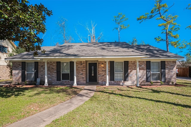 ranch-style home featuring a porch, a front yard, and brick siding