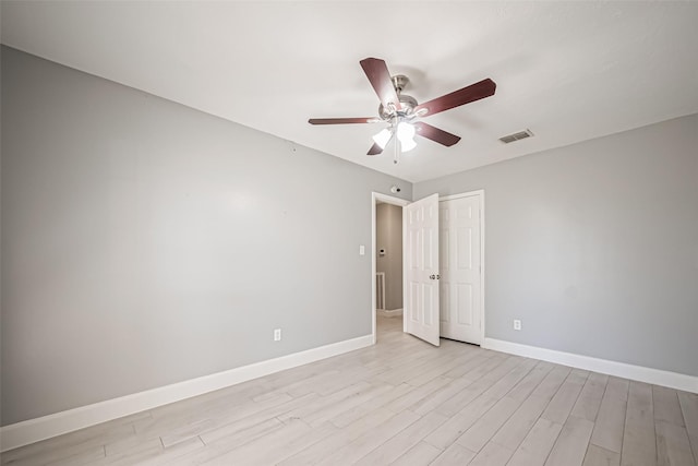 unfurnished room with light wood-style floors, visible vents, baseboards, and a ceiling fan