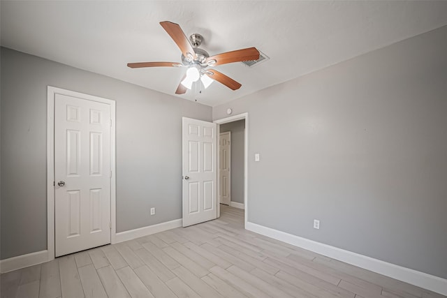 unfurnished bedroom featuring a ceiling fan, light wood-type flooring, visible vents, and baseboards