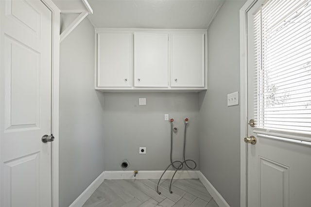 washroom featuring cabinet space, baseboards, hookup for a gas dryer, and hookup for an electric dryer