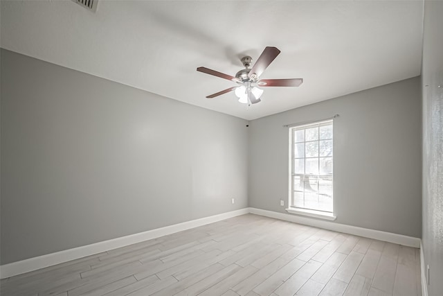 empty room with a ceiling fan, baseboards, and light wood finished floors