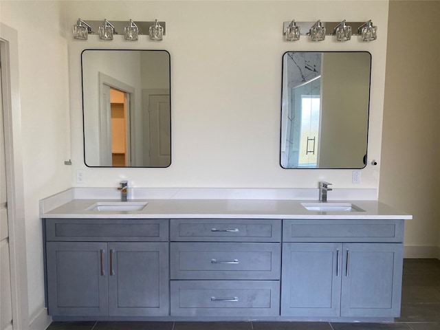 full bath with a sink, baseboards, and double vanity