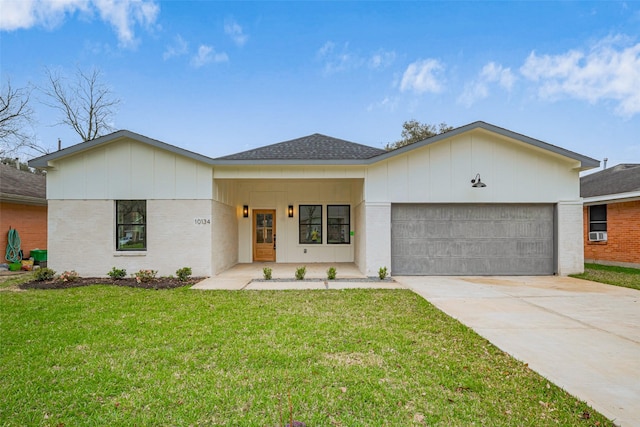 view of front of property with roof with shingles, concrete driveway, a front yard, an attached garage, and brick siding