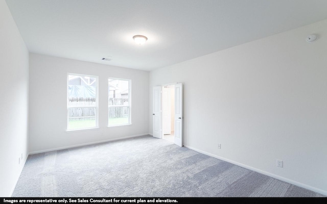 spare room featuring carpet and baseboards