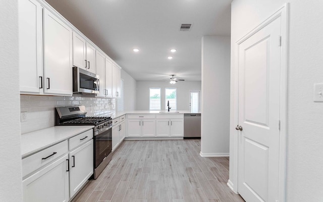 13709 Seneca Lake Dr, Texas City, TX 77568 - kitchen featuring appliances with stainless steel finishes, recessed lighting, a sink, tasteful backsplash, and white cabinetry