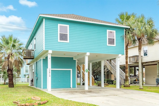 coastal inspired home featuring a shingled roof, stairway, a garage, a carport, and a front lawn