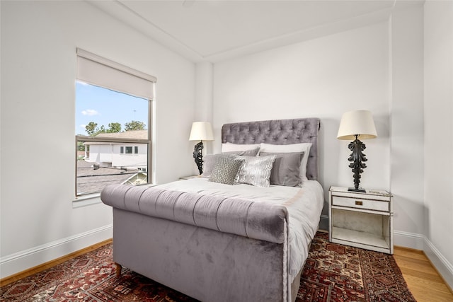 bedroom featuring baseboards and wood finished floors