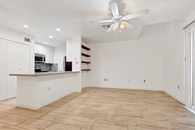 kitchen with stainless steel appliances, tasteful backsplash, visible vents, and white cabinetry