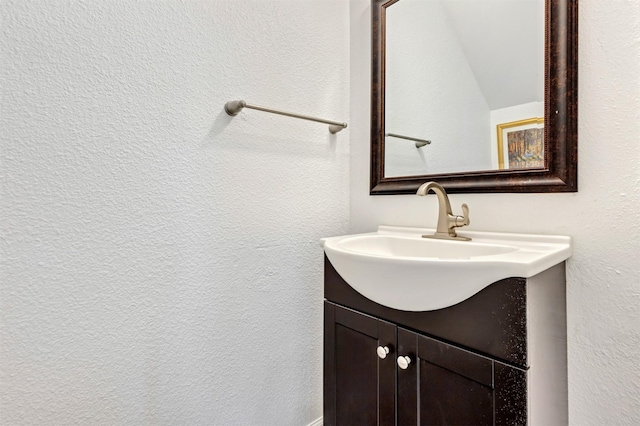 bathroom with a textured wall and vanity