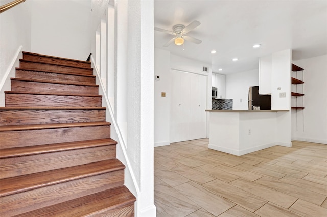 stairs featuring ceiling fan, baseboards, wood finished floors, and recessed lighting