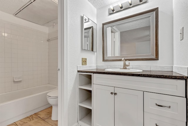 bathroom featuring a textured wall, toilet, tub / shower combination, vanity, and a textured ceiling