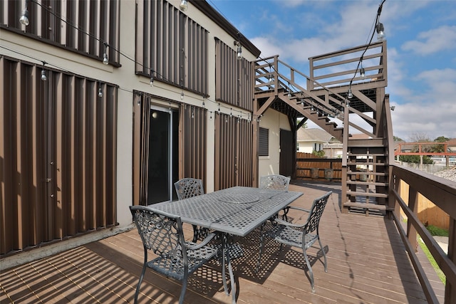 wooden deck featuring outdoor dining area and stairs