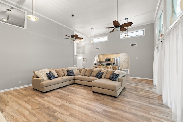 living room with ceiling fan, ornamental molding, light wood-type flooring, and visible vents