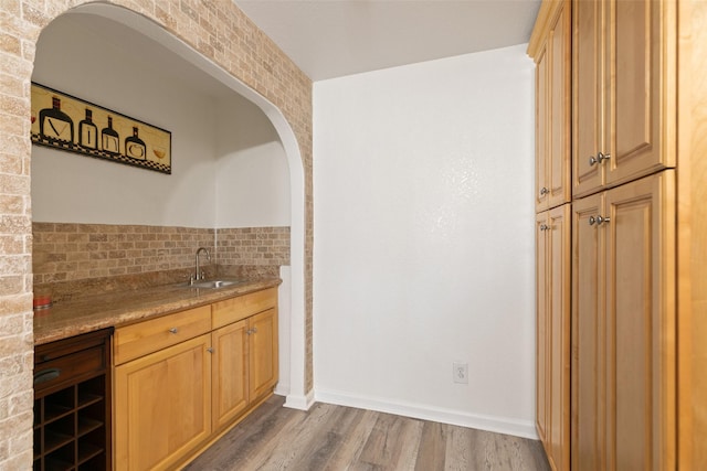 interior space featuring wood finished floors, a sink, and baseboards