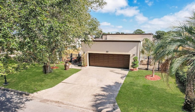 view of front of house with an attached garage, fence, concrete driveway, stucco siding, and a front yard