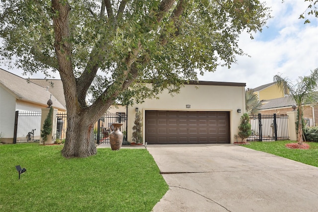 view of front facade with stucco siding, concrete driveway, an attached garage, fence, and a front lawn