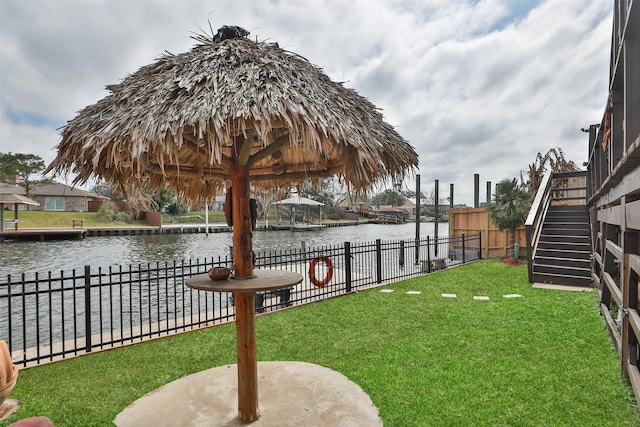 view of yard featuring stairs, a water view, and fence