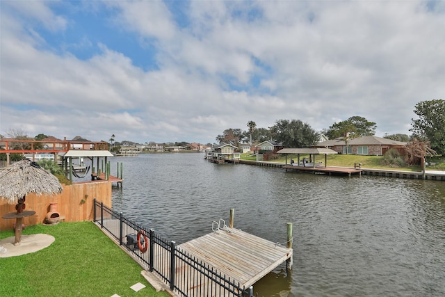 dock area with a yard, a water view, and a residential view