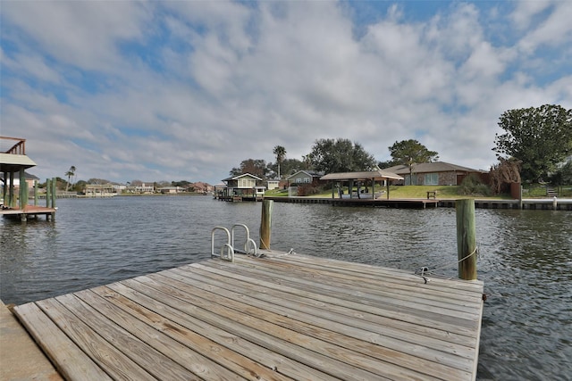 view of dock with a water view and a residential view