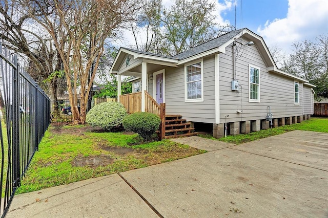 bungalow-style house featuring roof with shingles and fence