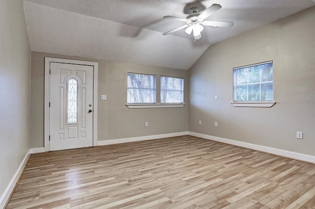 entrance foyer with light wood-style floors, lofted ceiling, a textured ceiling, and a ceiling fan