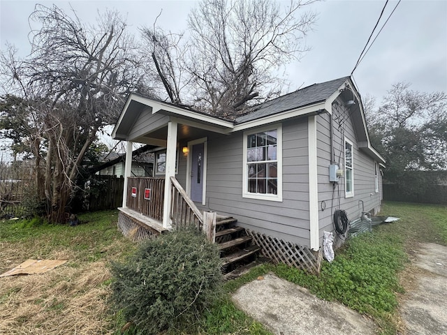 bungalow-style home featuring covered porch and fence