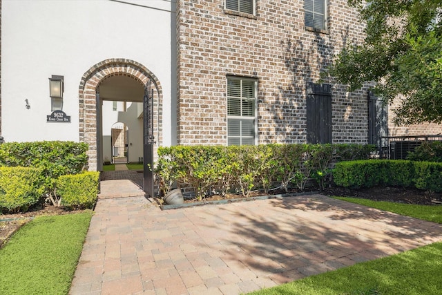 doorway to property featuring brick siding