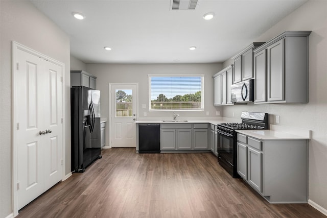 23923 Falling Daylight Dr, Hockley, TX 77447 - kitchen featuring black appliances, gray cabinetry, a sink, wood finished floors, and light countertops