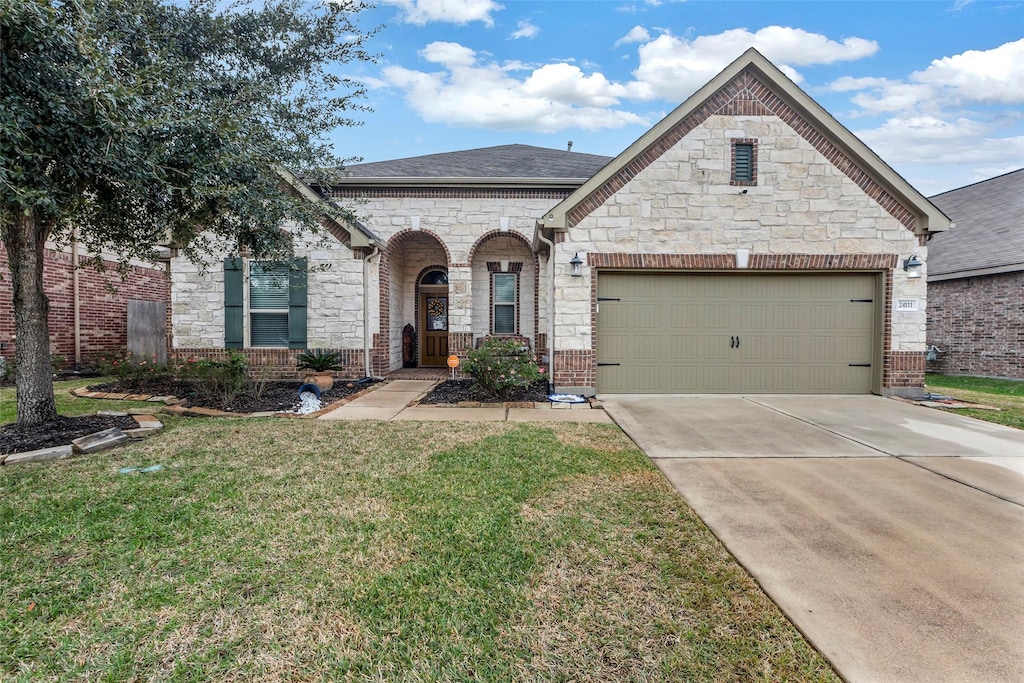 french provincial home with brick siding, roof with shingles, an attached garage, a front yard, and driveway