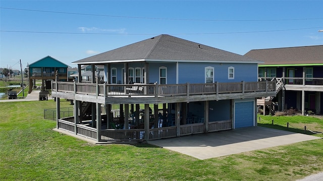 back of property featuring driveway, a garage, a shingled roof, a deck, and a yard