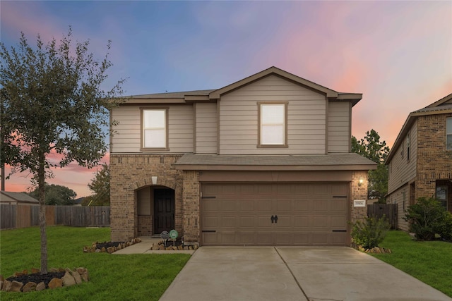 traditional home featuring concrete driveway, brick siding, a yard, and fence