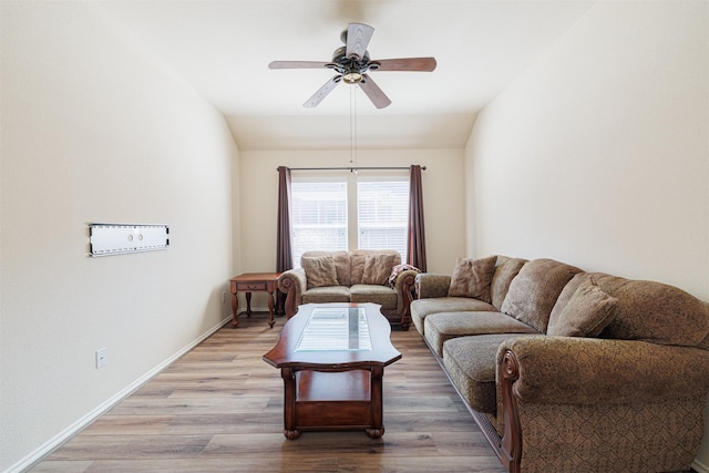 living room with light wood-style floors, vaulted ceiling, baseboards, and a ceiling fan