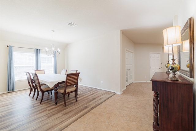 dining area featuring baseboards, light wood-type flooring, visible vents, and a notable chandelier