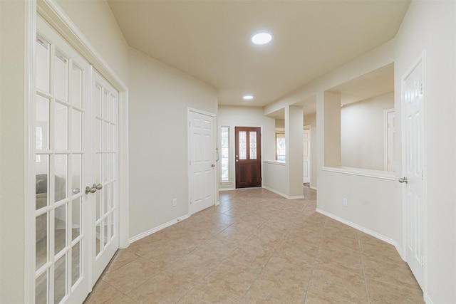 entryway featuring recessed lighting, french doors, light tile patterned flooring, and baseboards