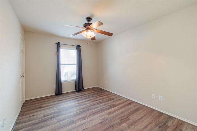 unfurnished room with ceiling fan, baseboards, and wood finished floors